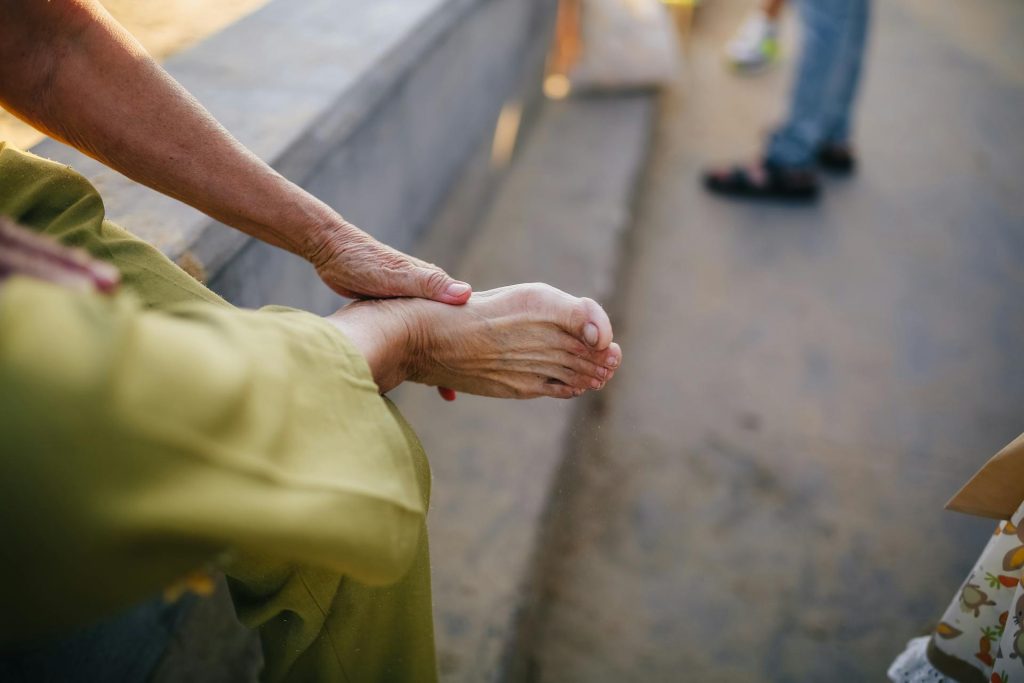 An image of a woman touching his feet representing heel fat pad pain. Heel fat pad syndrome is the name given when the natural cushion of fatty tissue just below the heel becomes damaged or thins out and loses its shock-absorbing qualities. The result is a deep bruise-like pain when standing or walking. It is the second most common cause of heel pain after plantar fasciitis and is frequently misdiagnosed as plantar fasciitis. The difference is that plantar fasciitis involves the ligament, and fat pad syndrome involves the pad.